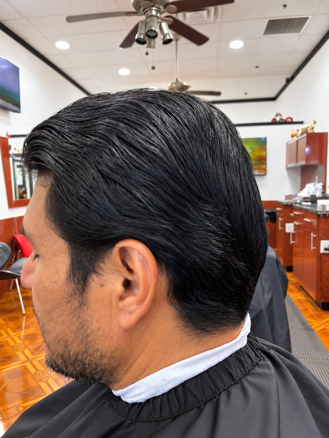Men's classic slicked-back haircut in profile at Zara Barbershop