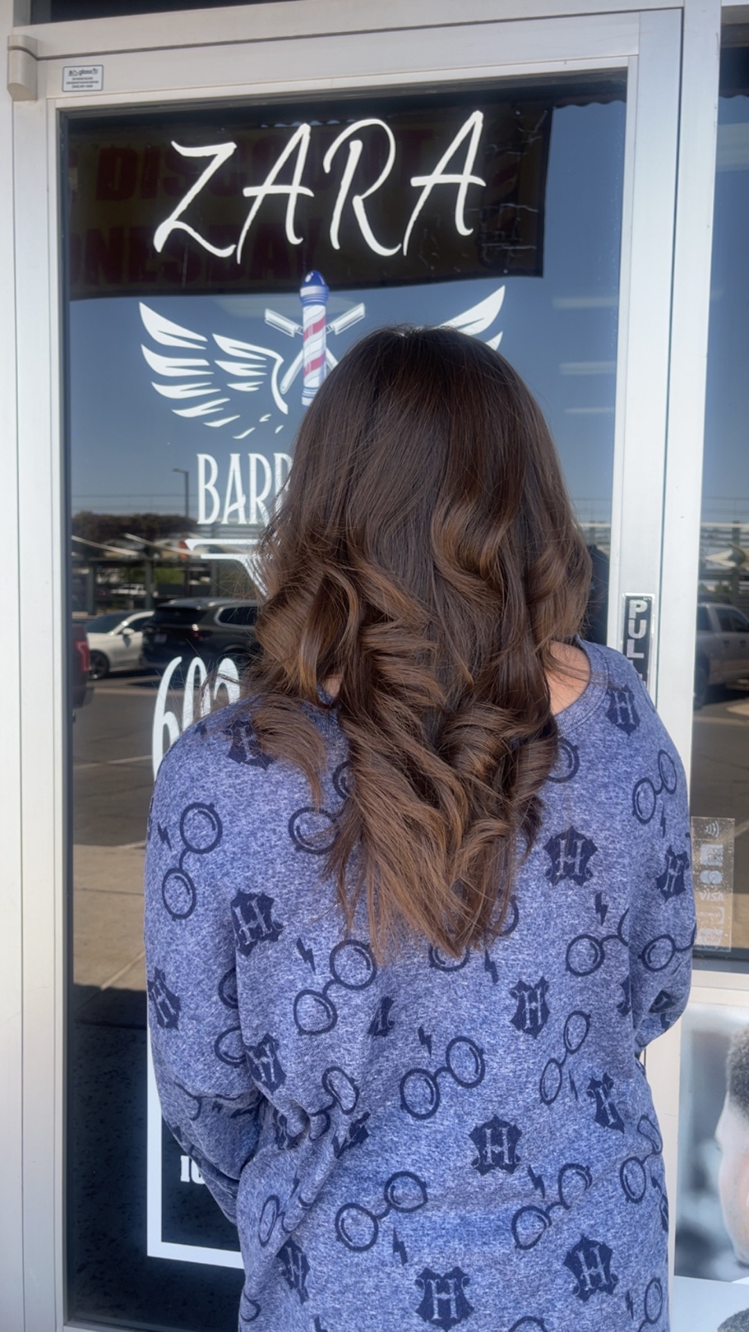 Women's balayage with bouncy curls outside Zara Barbershop