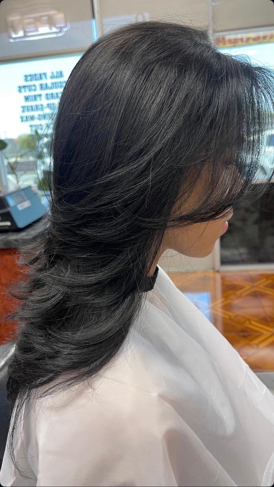 Long layered women's haircut with feathered ends